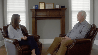 O jurnalistă îi ia un interviu profesorului Walter Balle în casa sa.